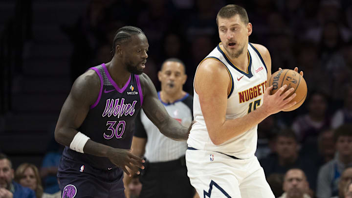 Nov 15, 2025; Minneapolis, Minnesota, USA; Denver Nuggets center Nikola Jokic (15) dribbles the ball as Minnesota Timberwolves forward Julius Randle (30) plays defense in the first half at Target Center.