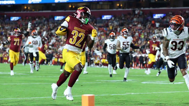 Aug 18, 2025; Landover, Maryland, USA; Washington Commanders running back Jacory Croskey-Merritt (32) scores a touchdown past Cincinnati Bengals safety Daijahn Anthony (33) during the first half at Northwest Stadium. Mandatory Credit: Amber Searls-Imagn Images