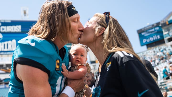 Jacksonville Jaguars quarterback Trevor Lawrence (16) gives his wife Marissa Layne Lawrence a kiss before the start of the game with their daughter Shae Lynn.