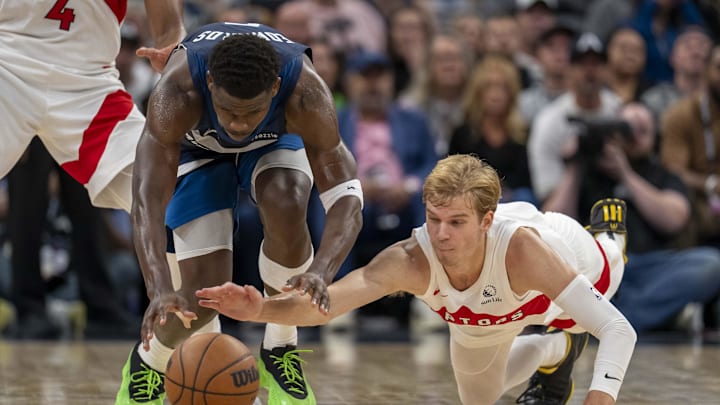Oct 26, 2024; Minneapolis, Minnesota, USA; Minnesota Timberwolves guard Anthony Edwards (5) and Toronto Raptors guard Gradey Dick (1) dive for a loose ball in the second half at Target Center. Mandatory Credit: Jesse Johnson-Imagn Images