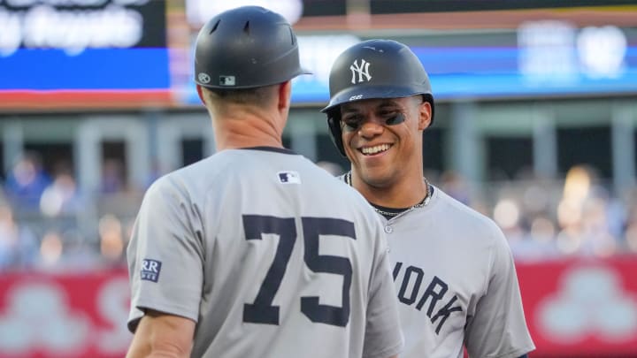 Jun 10, 2024; Kansas City, Missouri, USA; New York Yankees designated hitter Juan Soto (22) celebrates with first base coach Travis Chapman (75) after hitting a single against the Kansas City Royals in the first inning at Kauffman Stadium. Mandatory Credit: Denny Medley-USA TODAY Sports