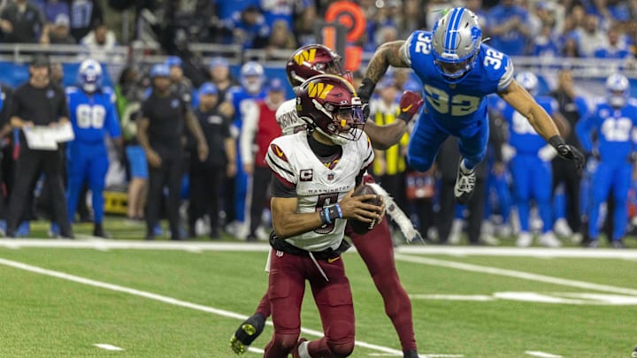 Jan 18, 2025; Detroit, Michigan, USA; Washington Commanders quarterback Jayden Daniels (5) looks to pass as running back Brian Robinson Jr. (8) defends against Detroit Lions defensive back Brian Branch (32) during the second half at Ford Field. Mandatory Credit: David Reginek-Imagn Images