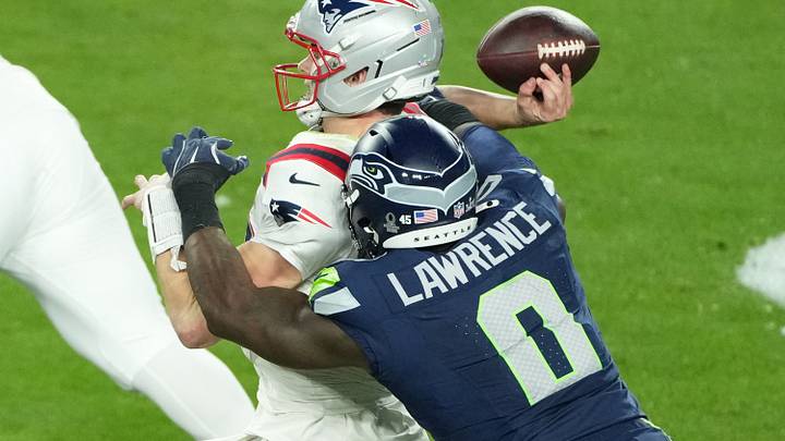 New England Patriots quarterback Drake Maye (10) is hit as he throws by Seattle Seahawks defensive end DeMarcus Lawrence (0).