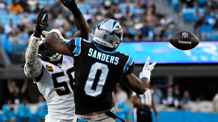 Nov 3, 2024; Charlotte, North Carolina, USA; Carolina Panthers tight end Ja'Tavion Sanders (0) attempts to catch the ball as New Orleans Saints linebacker Demario Davis (56) defends in the fourth qarter at Bank of America Stadium. 