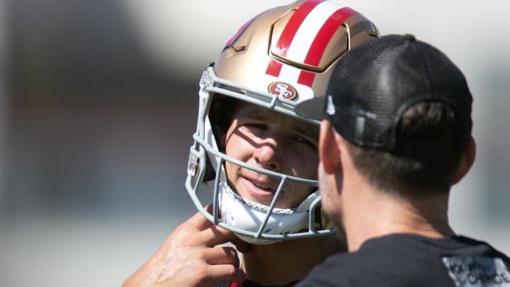 Jul 26, 2024; Santa Clara, CA, USA; San Francisco 49ers quarterback Brock Purdy (13) talks with a coach during Day 4 of training camp at SAP Performance Facility. Mandatory Credit: D. Ross Cameron-USA TODAY Sports Jul 26, 2024; Santa Clara, CA, USA; San Francisco 49ers quarterback Brock Purdy (13) talks with a coach during Day 4 of training camp at SAP Performance Facility. Mandatory Credit: D. Ross Cameron-USA TODAY Sports