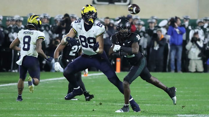 Michigan Wolverines tight end AJ Barner (89) makes a catch against Michigan State Spartans defensive back Chester Kimbrough (12) during second-half action at Spartan Stadium in East Lansing on Saturday, Oct. 21, 2023.