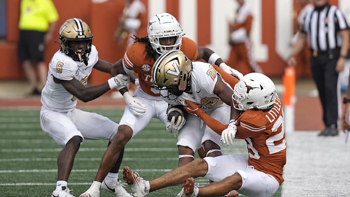 Nov 1, 2025; Austin, Texas, USA; Texas Longhorns defensive backs Graceson Littleton (29) and Jaylon Guilbeau (3) tackle Vanderbilt Commodores running back Makhilyn Young (22) during the first half  at Darrell K Royal-Texas Memorial Stadium. Mandatory Credit: Scott Wachter-Imagn Images
