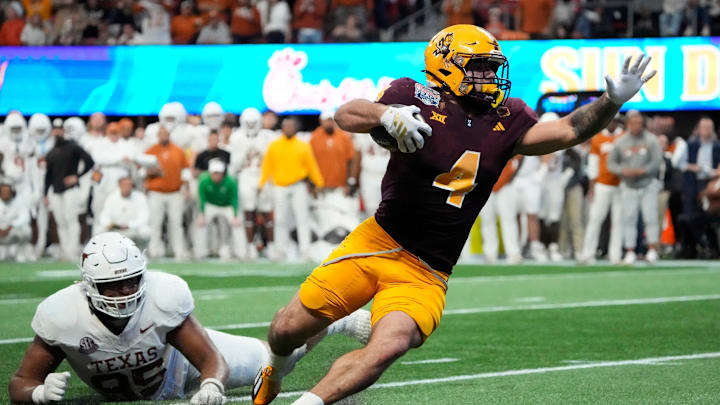 Arizona State running back Cam Skattebo (4) escapes a tackle by Texas defensive lineman Alfred Collins. Arizona State running back Cam Skattebo (4) escapes a tackle by Texas defensive lineman Alfred Collins.