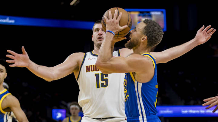 Golden State Warriors guard Stephen Curry (30) is defended by Denver Nuggets center Nikola Jokic (15) during the second half at Chase Center. Mandatory Credit: John Hefti-Imagn Images