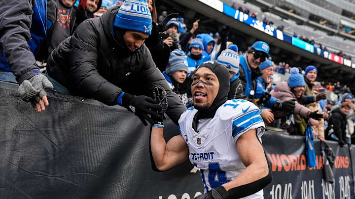 Detroit Lions wide receiver Amon-Ra St. Brown (14) high-fives fans.