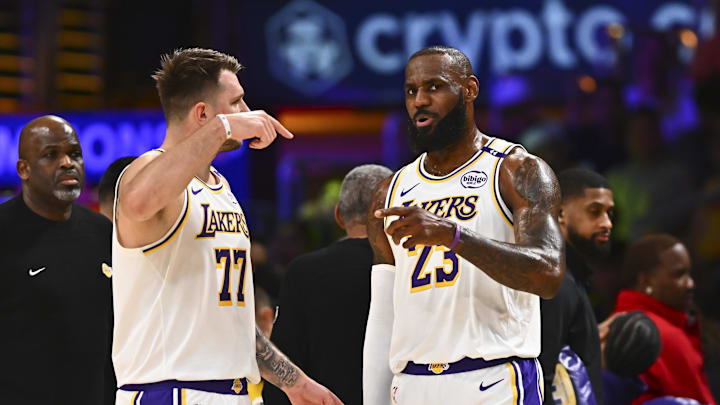 Mar 22, 2025; Los Angeles, California, USA; Los Angeles Lakers guard Luka Doncic (77) and Los Angeles Lakers forward LeBron James (23) on the sidelines against the Chicago Bulls during the first half at Crypto.com Arena. Mandatory Credit: Jonathan Hui-Imagn Images