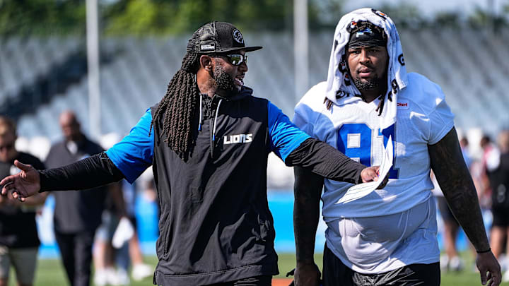 Detroit Lions defensive coordinator Kelvin Sheppard, left, talk to defensive tackle Tyleik Williams (91) as they walk off the field after practice during training camp at Meijer Performance Center in Allen Park on Thursday, July 24, 2025.