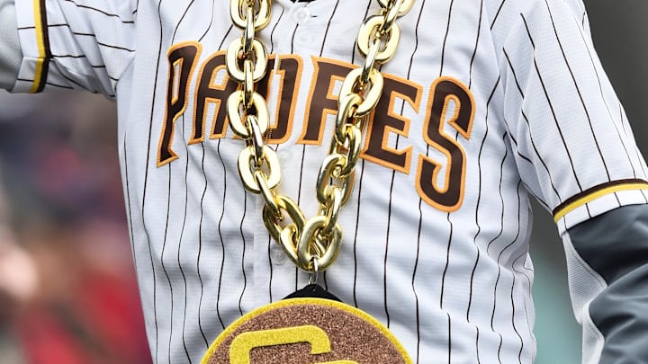 May 4, 2022; Cleveland, Ohio, USA; A young fan shows his San Diego Padres jersey to third baseman Manny Machado (13) during the eighth inning against the Cleveland Guardians at Progressive Field. Mandatory Credit: Ken Blaze-Imagn Images