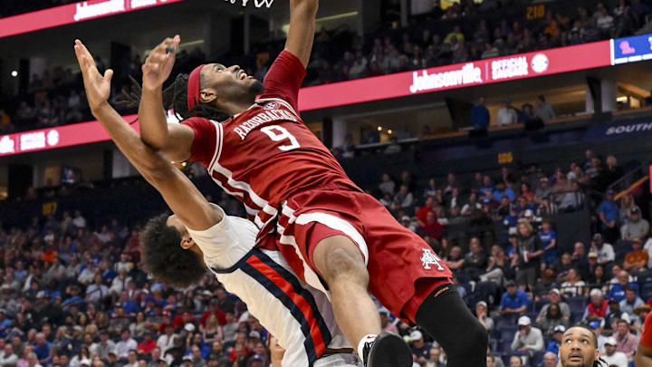 Mar 13, 2025; Nashville, TN, USA;  Arkansas Razorbacks forward Jonas Aidoo (9) shoots over Mississippi Rebels forward Jaemyn Brakefield (4) during the second half at Bridgestone Arena. Mandatory Credit: Steve Roberts-Imagn Images