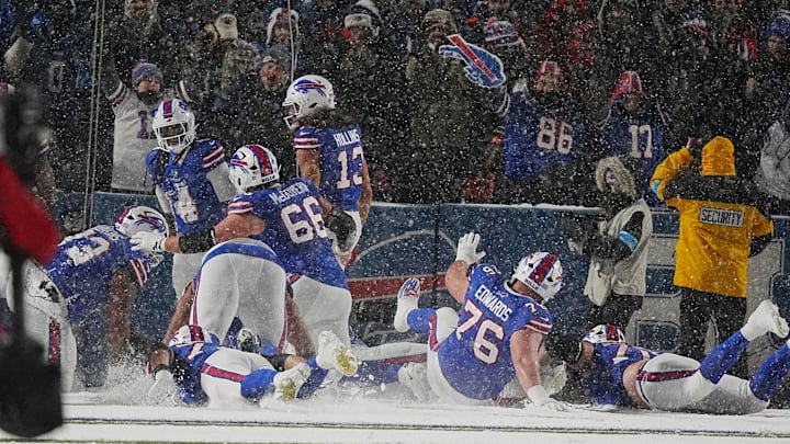 Bills offensive line slide in the snow in the end zone to celebrate James Cook's touchdown.