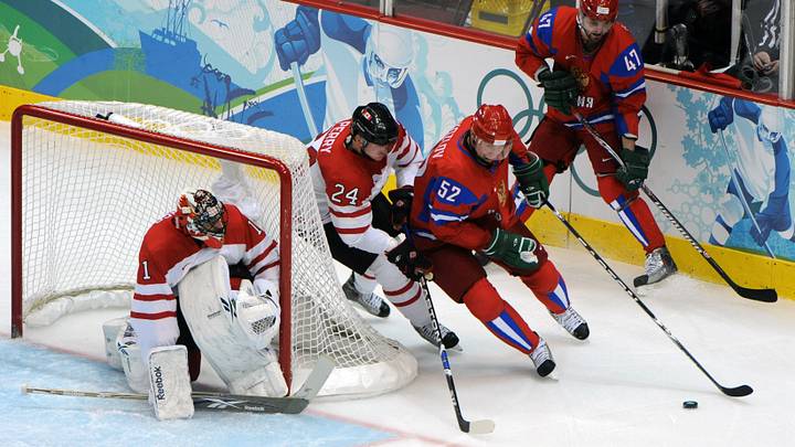 Feb 24, 2010; Vancouver, BC, CANADA; Russia forward Viktor Kozlov (52) controls the puck in front of Canada forward Corey Perry (24) in the first period during the mens hockey quarterfinal match in the 2010 Vancouver Winter Olympics at Canada Hockey Place. Mandatory Credit: Kyle Terada-USA TODAY Sports