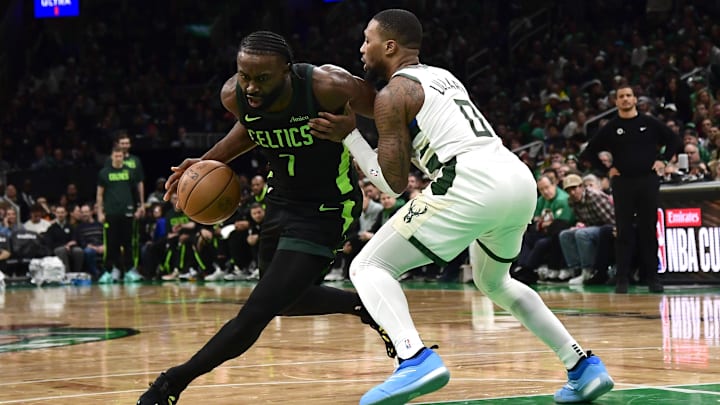 Dec 6, 2024; Boston, Massachusetts, USA;  Boston Celtics guard Jaylen Brown (7) controls the ball while Milwaukee Bucks guard Damian Lillard (0) defends during the second half at TD Garden. Mandatory Credit: Bob DeChiara-Imagn Images