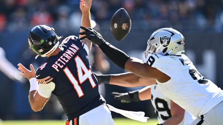 Oct 22, 2023; Chicago, Illinois, USA;  Chicago Bears quarterback Nathan Peterman (14) has the ball stripped away by Las Vegas Raiders defensive end Tyree Wilson (9) in the second quarter at Soldier Field. Mandatory Credit: Jamie Sabau-USA TODAY Sports