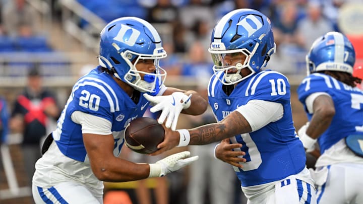 Nov 15, 2025; Durham, North Carolina, USA; Duke Blue Devils quarter back Darian Mensah (10) hands the ball to Duke Blue Devils running back Nate Sheppard (20) against the Virginia Cavaliers during the first quarter at Wallace Wade Stadium. Mandatory Credit: Zachary Taft-Imagn Images