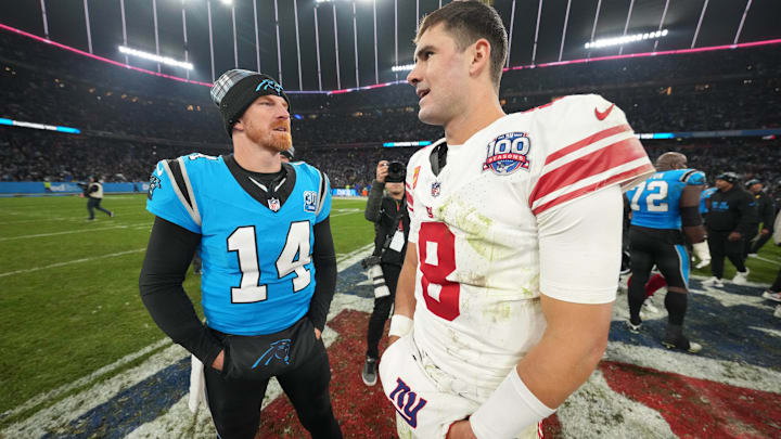 Nov 10, 2024; Munich, Germany; Carolina Panthers quarterback Andy Dalton (14) and New York Giants quarterback Daniel Jones (8) talk after the 2024 NFL Munich Game at Allianz Arena. 