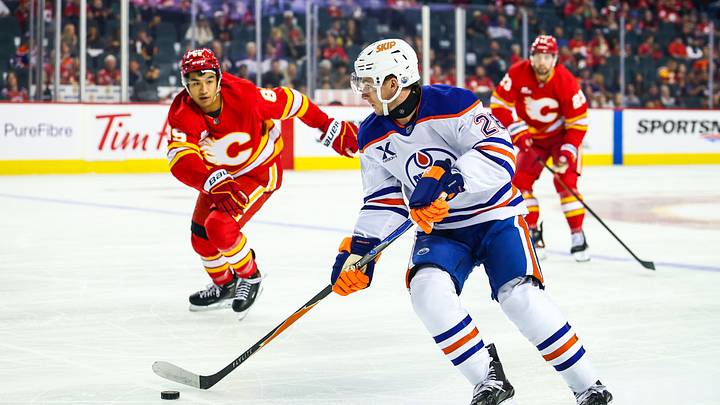 Sep 21, 2025; Calgary, Alberta, CAN; Edmonton Oilers right wing Quinn Hutson (28) controls the puck against the Calgary Flames during the first period at Scotiabank Saddledome. Mandatory Credit: Sergei Belski-Imagn Images
