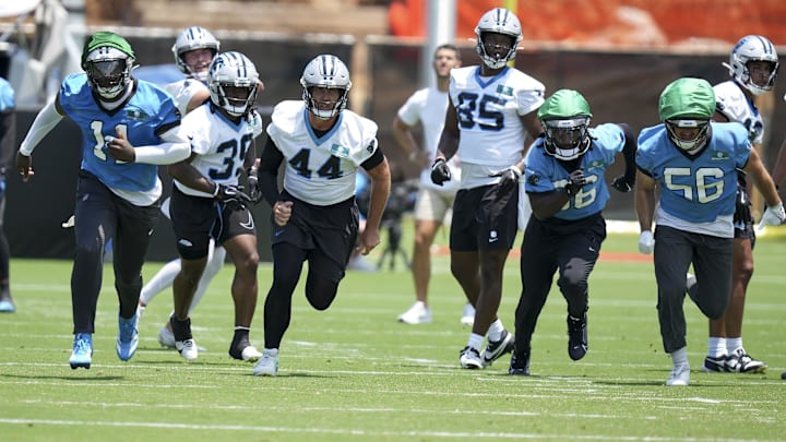 Carolina Panthers LB Nic Scourton, CB Mike Reid, LS JJ Jansen, TE James Mitchell, S Demani Richardson, and LB Christian Rozeboom hustle to the ball during minicamp at Bank of America Stadium.