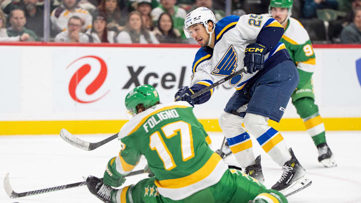 Mar 15, 2025; Saint Paul, Minnesota, USA; St. Louis Blues center Jordan Kyrou (25) shoots and scores on the open net as Minnesota Wild left wing Marcus Foligno (17) cannot block the shot in the third period at Xcel Energy Center. Mandatory Credit: Matt Blewett-Imagn Images