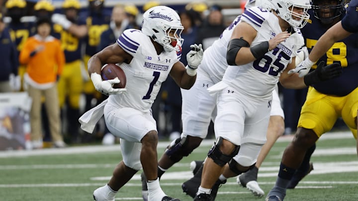 Nov 23, 2024; Ann Arbor, Michigan, USA;  Northwestern Wildcats running back Cam Porter (1) runs the ball against the Michigan Wolverines in the first half at Michigan Stadium. Mandatory Credit: Rick Osentoski-Imagn Images