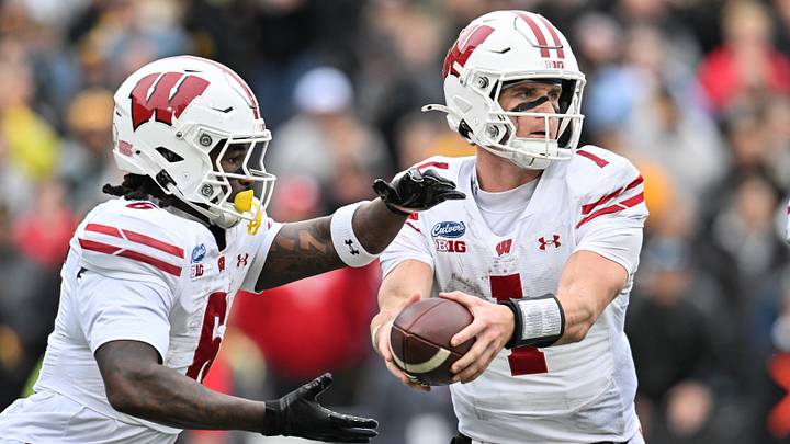 Wisconsin Badgers quarterback Colton Joseph (1) prepares to hand the ball off to running back Darrion Dupree (6). 