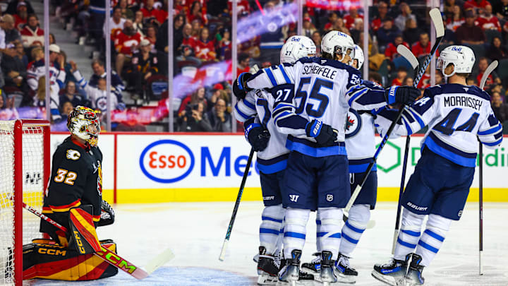 Oct 26, 2024; Calgary, Alberta, CAN; Winnipeg Jets left wing Nikolaj Ehlers (27) celebrates his goal with teammates against Calgary Flames goaltender Dustin Wolf (32) during the first period at Scotiabank Saddledome. Mandatory Credit: Sergei Belski-Imagn Images Oct 26, 2024; Calgary, Alberta, CAN; Winnipeg Jets left wing Nikolaj Ehlers (27) celebrates his goal with teammates against Calgary Flames goaltender Dustin Wolf (32) during the first period at Scotiabank Saddledome. Mandatory Credit: Sergei Belski-Imagn Images