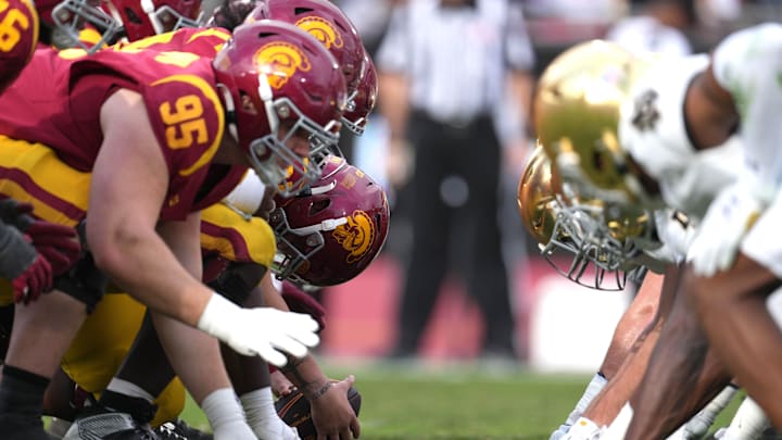Nov 30, 2024; Los Angeles, California, USA; A general view of Southern California Trojans and Notre Dame Fighting Irish helmets at the line of scrimmage in the first half at United Airlines Field at Los Angeles Memorial Coliseum. Mandatory Credit: Kirby Lee-Imagn Images
