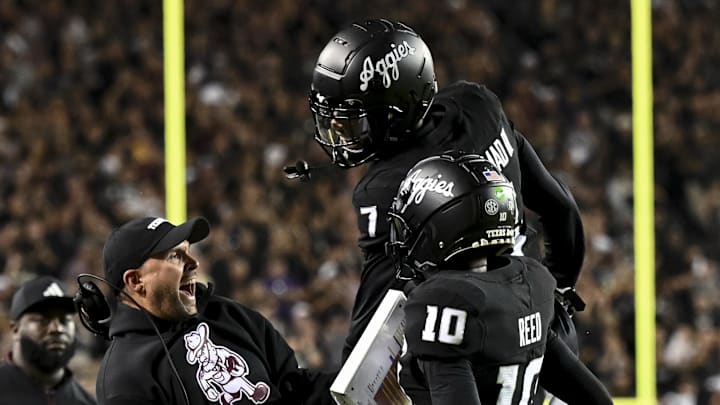 Oct 26, 2024; College Station, Texas, USA; Texas A&M Aggies quarterback Marcel Reed (10) celebrates after scoring a touchdown with Offensive Coordinator/Quarterbacks coach Collin Klein in the third quarter against the LSU Tigers at Kyle Field. Mandatory Credit: Maria Lysaker-Imagn Images. 