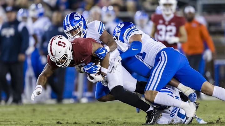 Nov 26, 2022; Stanford, California, USA;  Stanford Cardinal wide receiver Elijah Higgins (6) is tackled by Brigham Young Cougars defensive back Micah Harper (1) during the first half at Stanford Stadium. Mandatory Credit: John Hefti-Imagn Images