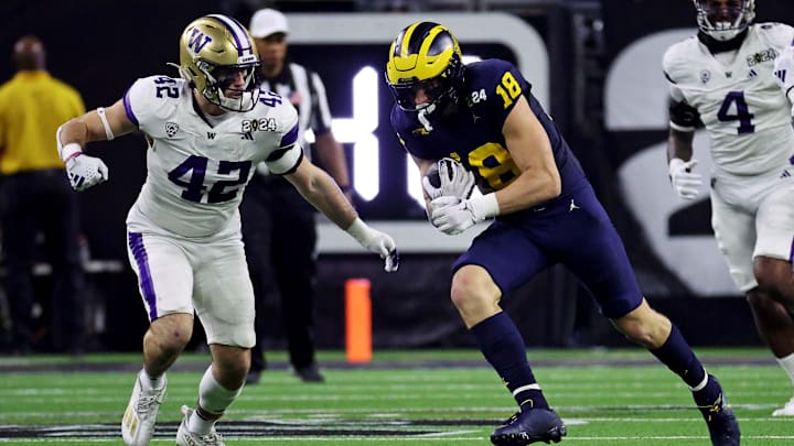 Jan 8, 2024; Houston, TX, USA; Michigan Wolverines tight end Colston Loveland (18) runs the ball against Washington Huskies linebacker Carson Bruener (42) during the second quarter in the 2024 College Football Playoff national championship game at NRG Stadium. Mandatory Credit: Troy Taormina-Imagn Images