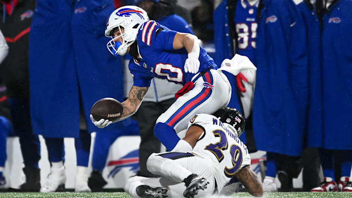 Buffalo Bills wide receiver Khalil Shakir tries to break a tackle by Baltimore Ravens safety Ar'Darius Washington.