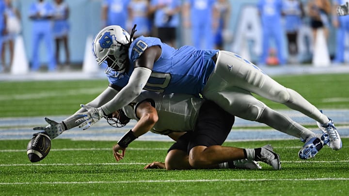 Sep 9, 2023; Chapel Hill, North Carolina, USA; North Carolina Tar Heels defensive lineman Desmond Evans (10) reaches for the ball over Appalachian State Mountaineers quarterback Joey Aguilar (4) in the fourth quarter at Kenan Memorial Stadium. Anguilar was ruled down before the ball was fumbled. Mandatory Credit: Bob Donnan-USA TODAY Sports