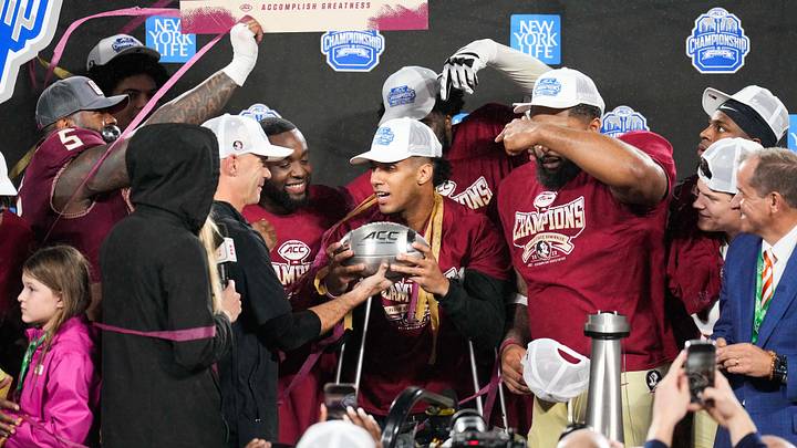 Dec 2, 2023; Charlotte, NC, USA; Florida State Seminoles quarterback Jordan Travis (13) holds the ACC Championship trophy after the game against the Louisville Cardinals at Bank of America Stadium. Mandatory Credit: Jim Dedmon-Imagn Images Dec 2, 2023; Charlotte, NC, USA; Florida State Seminoles quarterback Jordan Travis (13) holds the ACC Championship trophy after the game against the Louisville Cardinals at Bank of America Stadium. Mandatory Credit: Jim Dedmon-Imagn Images