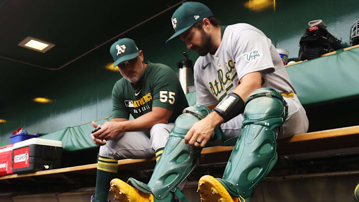 Sep 20, 2025; Pittsburgh, Pennsylvania, USA; Athletics catcher Shea Langeliers (23) prepares in the dugout alongside coach Ramon Hernandez (55) to play the Pittsburgh Pirates at PNC Park. Mandatory Credit: Charles LeClaire-Imagn Images