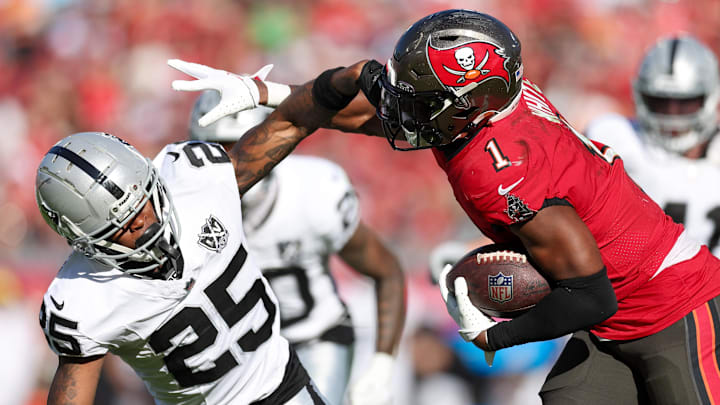 Dec 8, 2024; Tampa, Florida, USA; Tampa Bay Buccaneers running back Rachaad White (1) holds off Las Vegas Raiders cornerback Decamerion Richardson (25) in the third quarter at Raymond James Stadium. Mandatory Credit: Nathan Ray Seebeck-Imagn Images