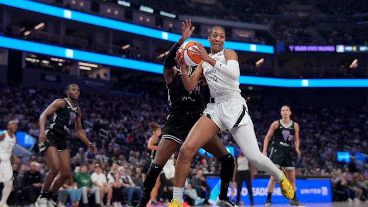 Aug 6, 2025; San Francisco, California, USA; Las Vegas Aces center A'ja Wilson (22) holds onto the ball next to Golden State Valkyries center Temi Fagbenle (14) in the second quarter at the Chase Center. 