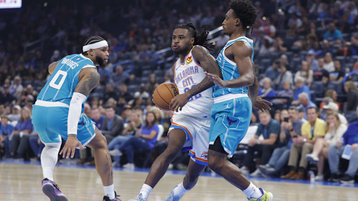 Oct 9, 2025; Oklahoma City, Oklahoma, USA; Oklahoma City Thunder guard Cason Wallace (22) drives down the court between Charlotte Hornets forward Miles Bridges (0) and guard Collin Sexton (8) during the second quarter of a game between the Charlotte Hornets and the Oklahoma City Thunder at Paycom Center. Mandatory Credit: Alonzo Adams-Imagn Images