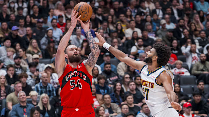 Oct 6, 2025; Vancouver, British Columbia, CAN; Toronto Raptors forward Sandro Mamukelashvili (54) shoots over Denver Nuggets guard Jamal Murray (27) in the first half at Rogers Arena. Mandatory Credit: Bob Frid-Imagn Images