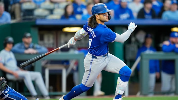 Apr 23, 2024; Kansas City, Missouri, USA; Toronto Blue Jays shortstop Bo Bichette (11) hits a single during the third inning against the Kansas City Royals at Kauffman Stadium. Mandatory Credit: Jay Biggerstaff-Imagn Images