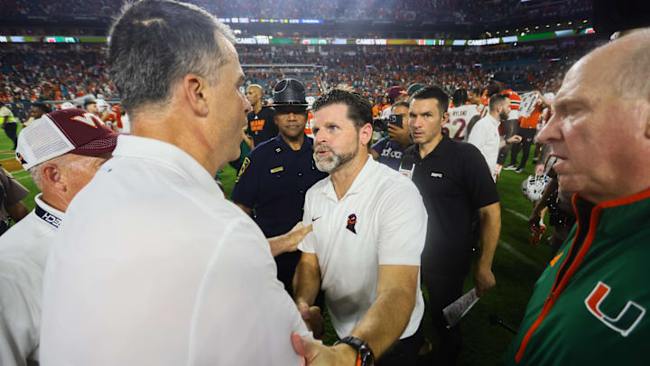 Sep 27, 2024; Miami Gardens, Florida, USA; Virginia Tech Hokies head coach Brent Pry shakes hands with Miami Hurricanes head coach Mario Cristobal after the game at Hard Rock Stadium. Mandatory Credit: Sam Navarro-Imagn Images Sep 27, 2024; Miami Gardens, Florida, USA; Virginia Tech Hokies head coach Brent Pry shakes hands with Miami Hurricanes head coach Mario Cristobal after the game at Hard Rock Stadium. Mandatory Credit: Sam Navarro-Imagn Images