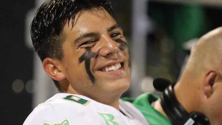 Dayton Raiola smiling on the sideline at his high school football game 
