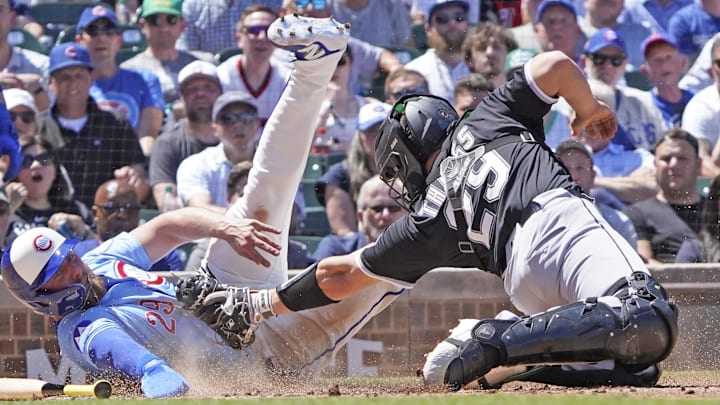 Cubs first baseman Michael Busch (29) avoids a tag from White Sox catcher Matt Thaiss (29) at Wrigley Field. Cubs first baseman Michael Busch (29) avoids a tag from White Sox catcher Matt Thaiss (29) at Wrigley Field.