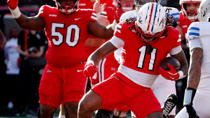 Western Kentucky running back La'Vell Wright (11) steps over Middle Tennessee linebacker Korey Smith (58) as he scores a touchdown during an NCAA College Football game at Western Kentucky on Saturday, Nov. 15, 2025.