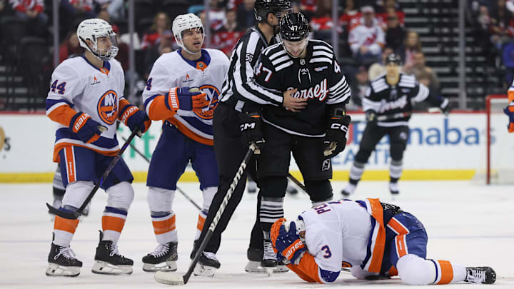 Apr 13, 2025; Newark, New Jersey, USA; New York Islanders defenseman Adam Pelech (3) lies on the ice after being hit in the head by New Jersey Devils center Paul Cotter (47) during the second period at Prudential Center. Mandatory Credit: Ed Mulholland-Imagn Images
