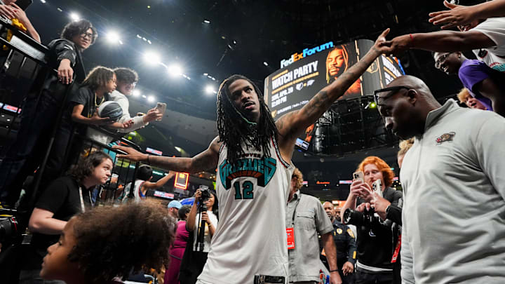 Grizzlies' Ja Morant (12) high fives fans as he walks off the court after the Grizzlies defeated the Mavericks 120-106 in the play-in game to secure a spot in the NBA Playoffs at FedExForum in Memphis, Tenn., on Friday, April 18, 2025.