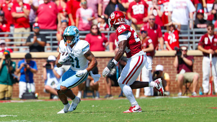 Sep 14, 2024; Norman, Oklahoma, USA; Tulane Green Wave running back Makhi Hughes (21) runs with the ball as Oklahoma Sooners linebacker Samuel Omosigho (24) defends during the first half at Gaylord Family-Oklahoma Memorial Stadium. Sep 14, 2024; Norman, Oklahoma, USA; Tulane Green Wave running back Makhi Hughes (21) runs with the ball as Oklahoma Sooners linebacker Samuel Omosigho (24) defends during the first half at Gaylord Family-Oklahoma Memorial Stadium.